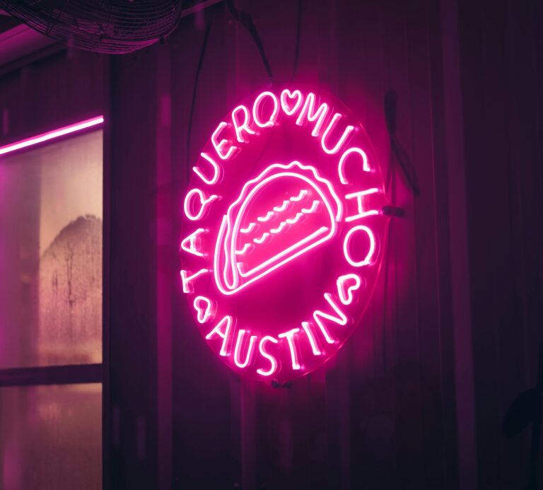 Neon pink sign in Austin reading “Taquero Mucho” with a glowing taco illustration, creating a playful and romantic ambiance — perfect for a fun date-night vibe.