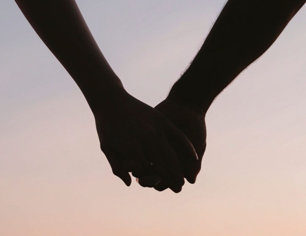 couple holding hands at sunset representing emotional connection and intimacy in relationship